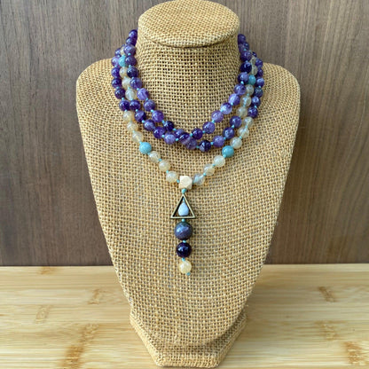 108 hand-knotted mala bead necklace featuring smooth amethyst, jade, and citrine gemstones, finished with a triangle and three-bead tassel